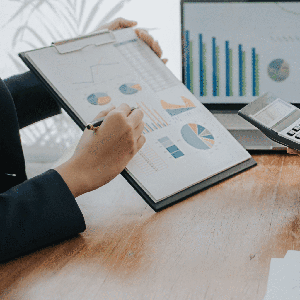 Mano señalando gráficos financieros en un informe impreso